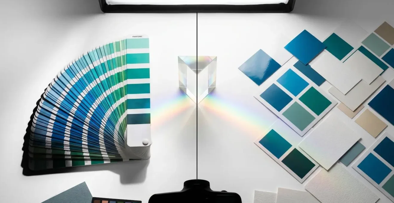 Composition artistique montrant un nuancier Pantone physique à côté d'échantillons de couleurs imprimés avec différentes techniques